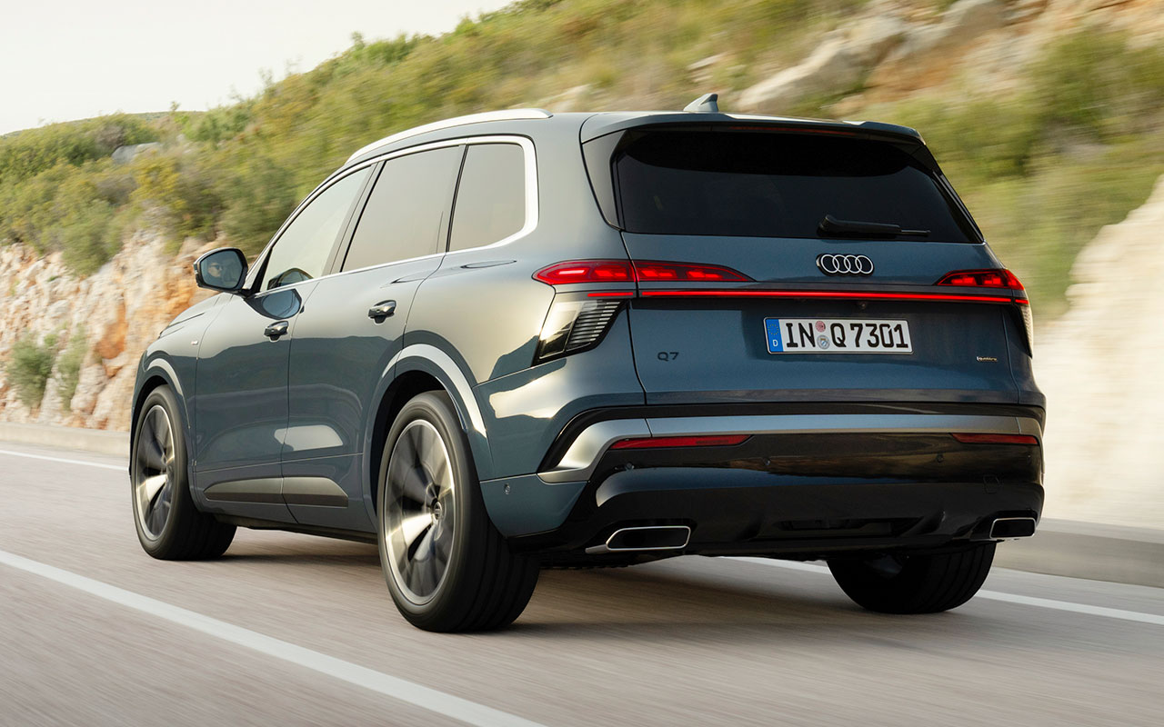 Audi Q7 azul visto de três quartos pela traseira em movimento na estrada