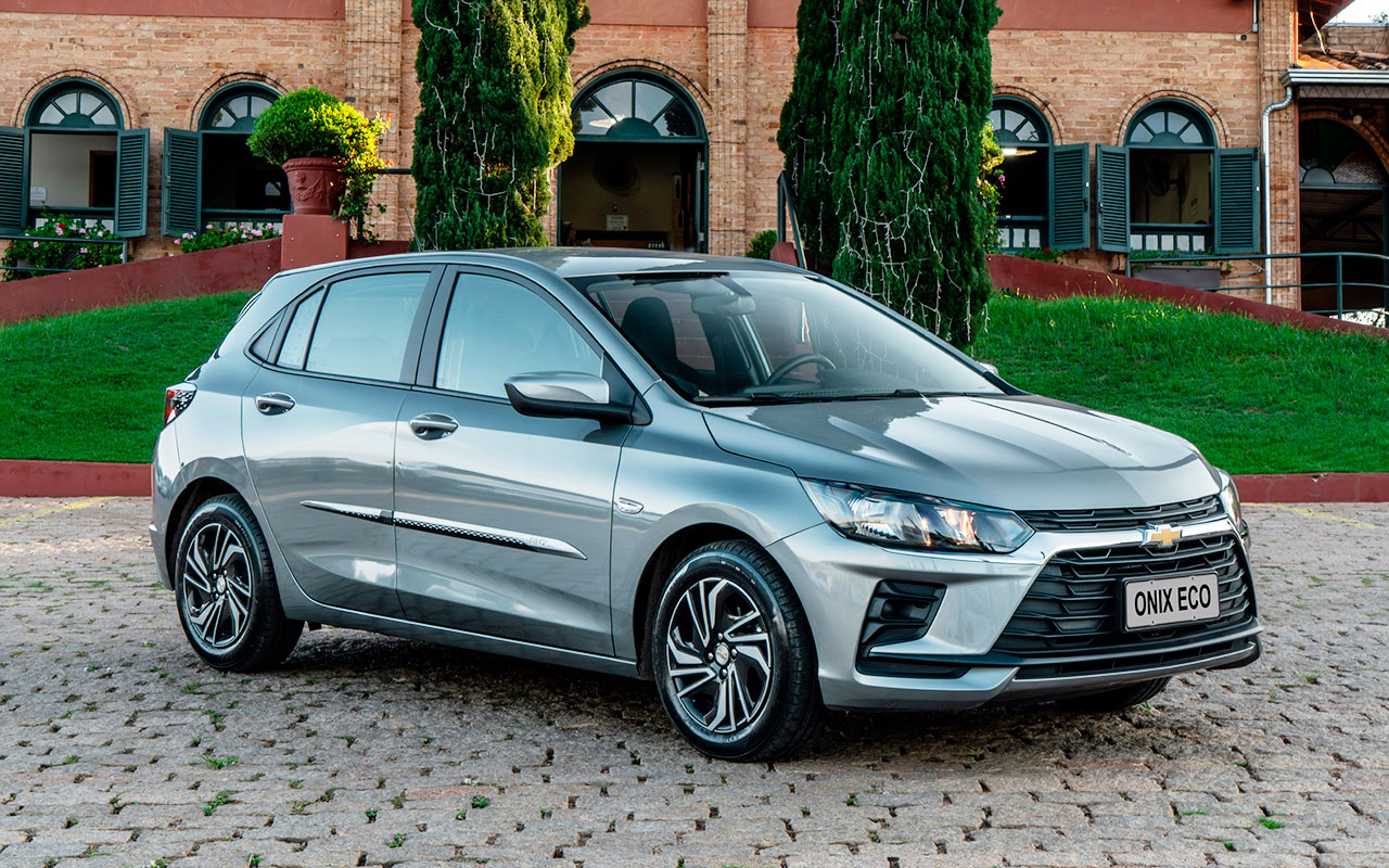 Chevrolet Onix ECO prata visto de três quartos dianteiros, com identificação da versão na placa