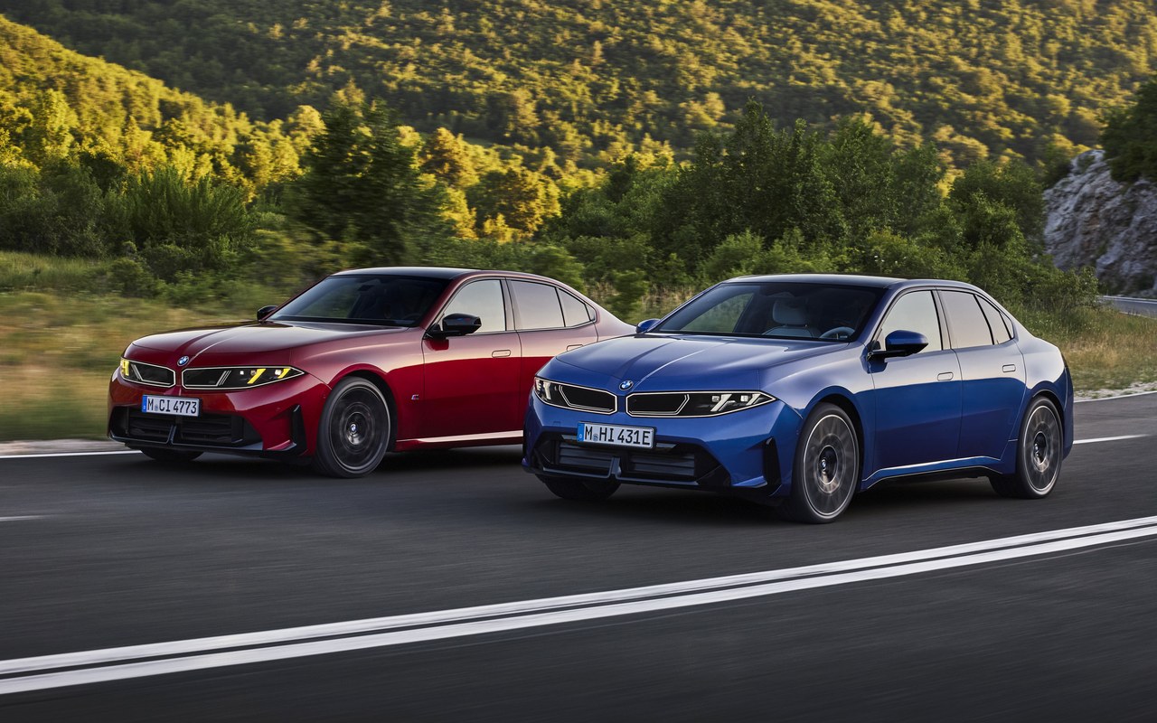 BMW i3 azul e M350 vermelho em movimento, vistos de frente em três quartos