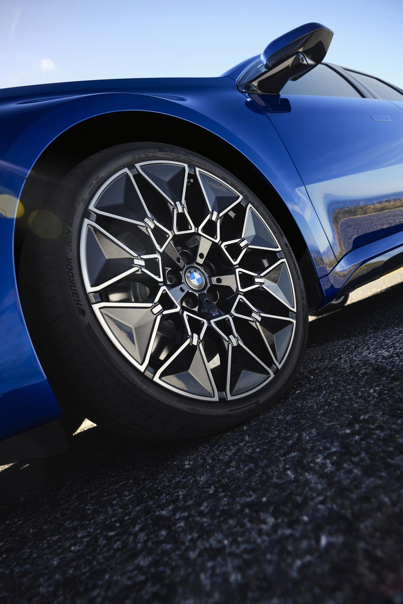 Roda dianteira e portinhola de recarga aberta do BMW i3 azul