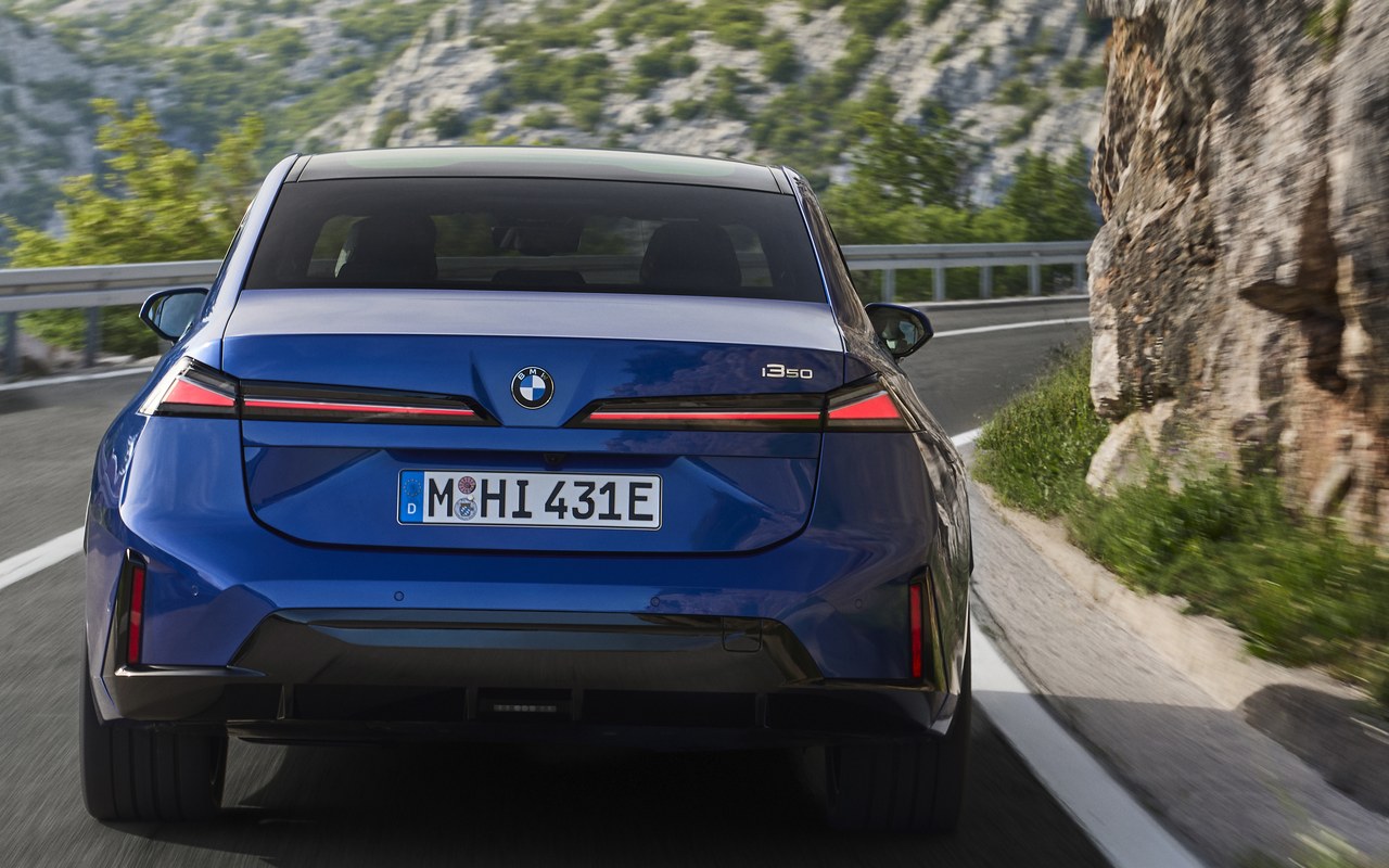 Traseira do BMW i3 azul em movimento numa estrada de montanha