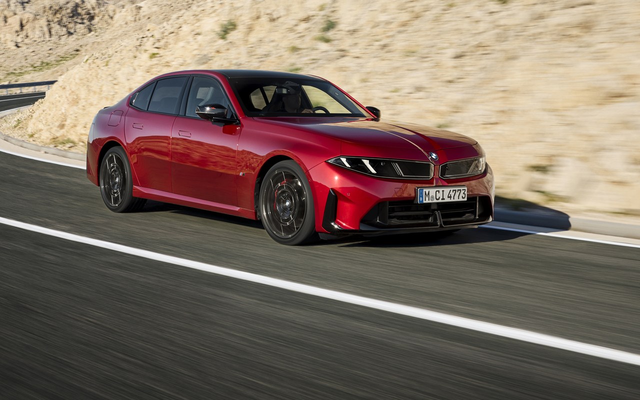 BMW M350 xDrive vermelho contornando uma curva, visto de frente em três quartos