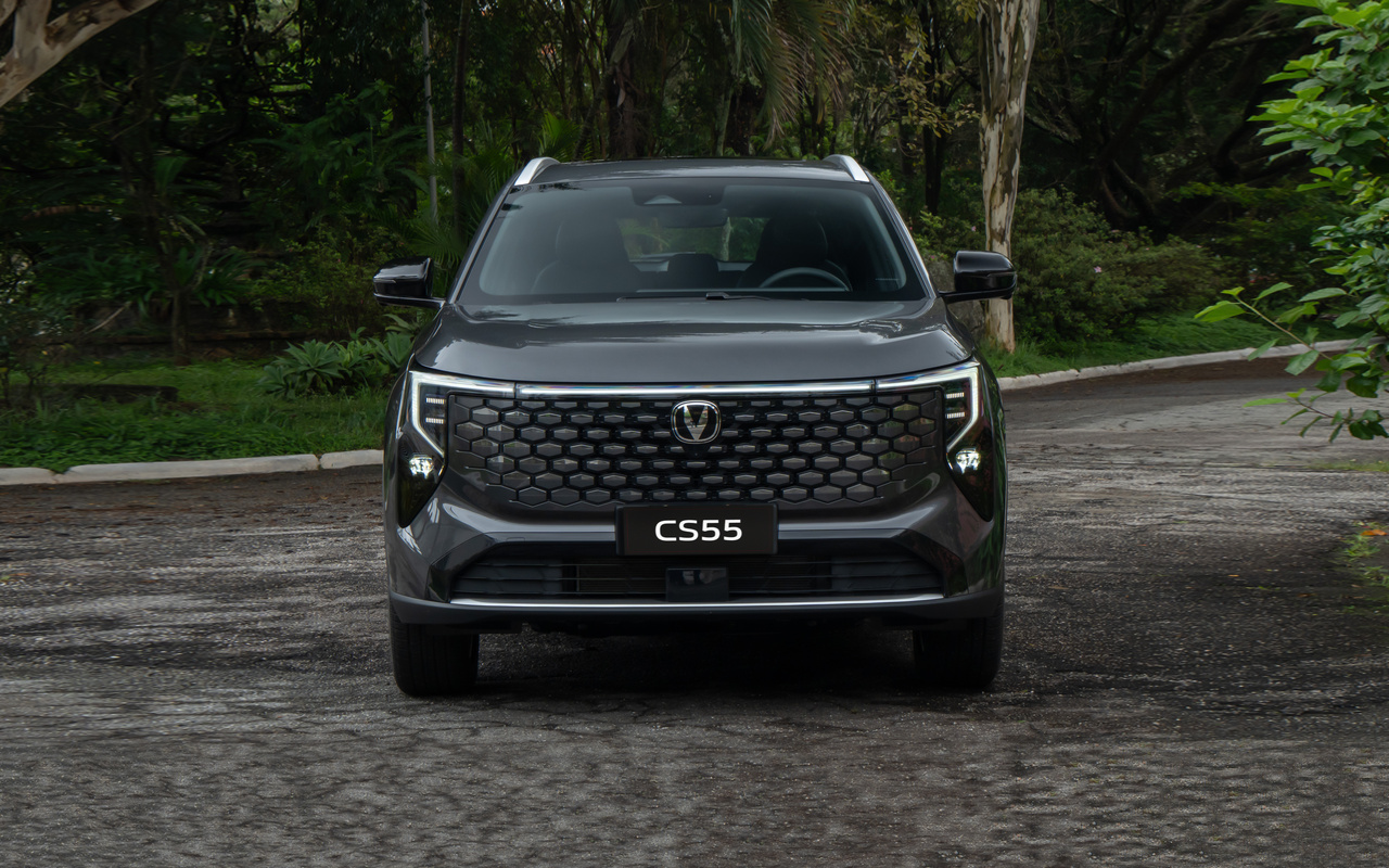 CAOA Changan CS55 cinza visto de frente, inteiro e centralizado em uma rua arborizada