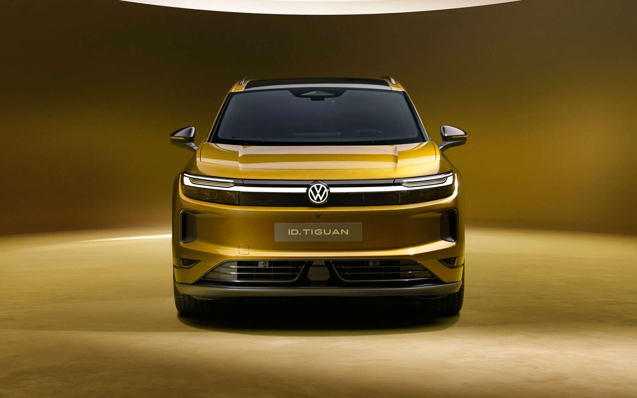 Volkswagen ID. Tiguan dourado visto de frente em estúdio, com faróis e emblema iluminados
