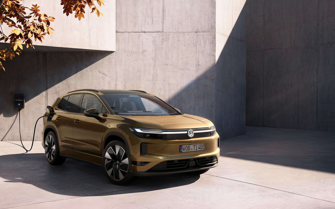Volkswagen ID. Tiguan dourado conectado por cabo a uma wallbox em uma parede