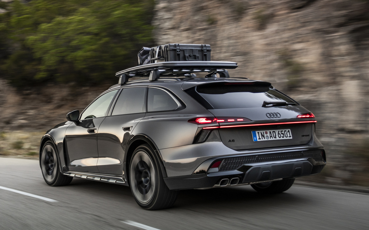 Audi A6 allroad TDI cinza vista de traseira e de lado em uma estrada, com bagageiro no teto