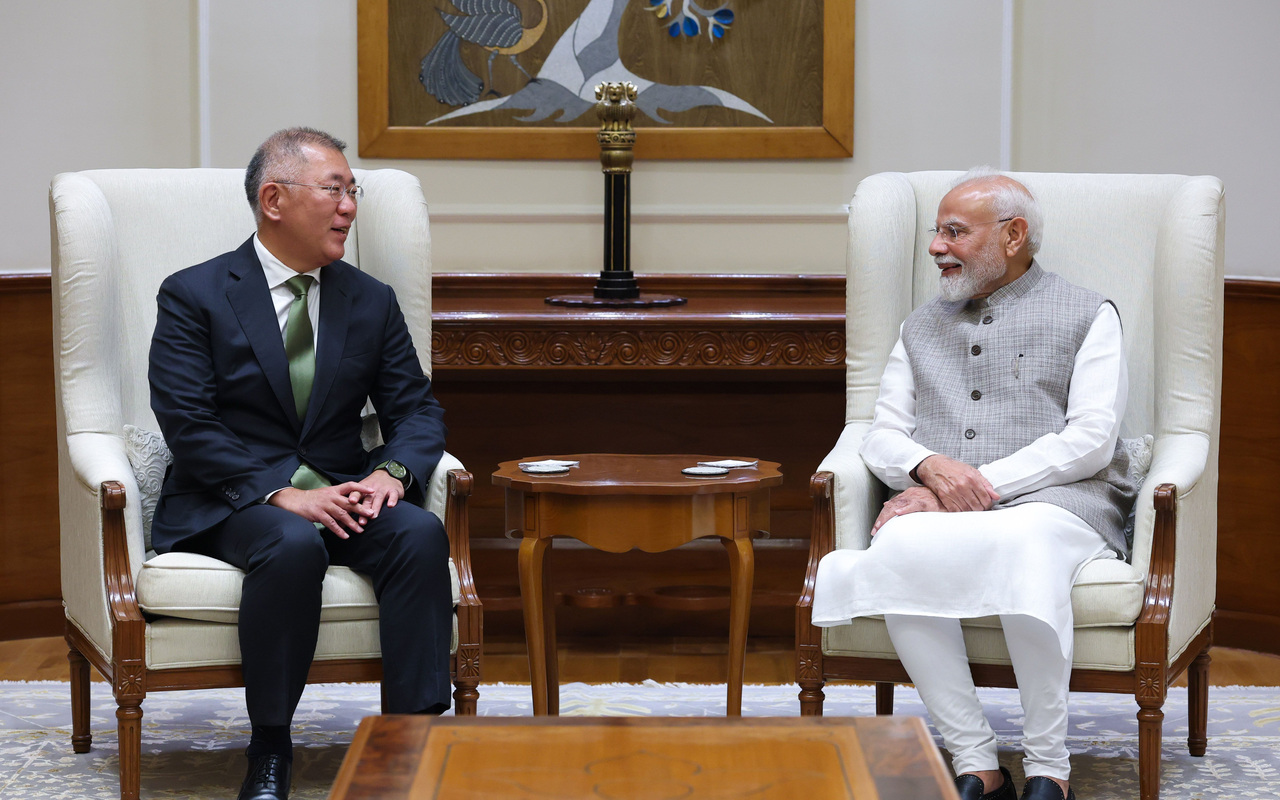 Euisun Chung e Narendra Modi conversam sentados em poltronas durante encontro na Índia.