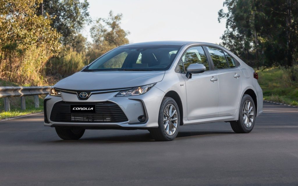 Toyota Corolla GLi Hybrid branco fotografado de frente e de lado em uma via