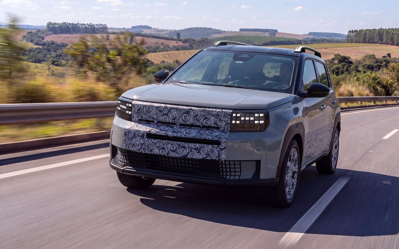 Protótipo cinza do Fiat Argo X visto de frente e de lado em rodovia, com camuflagem parcial
