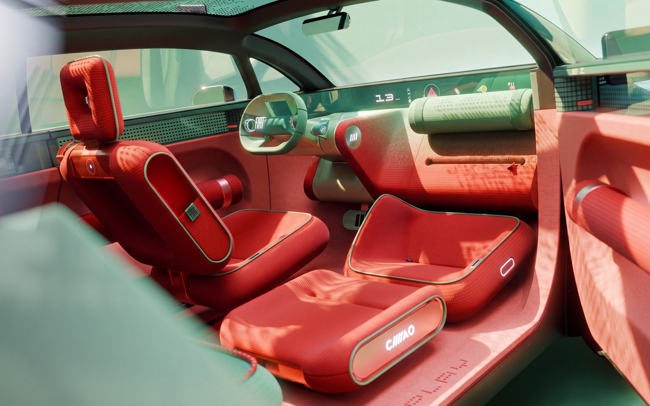 Interior do Fiat Multiplay com assento do passageiro estendido diante do painel e banco do motorista vermelho