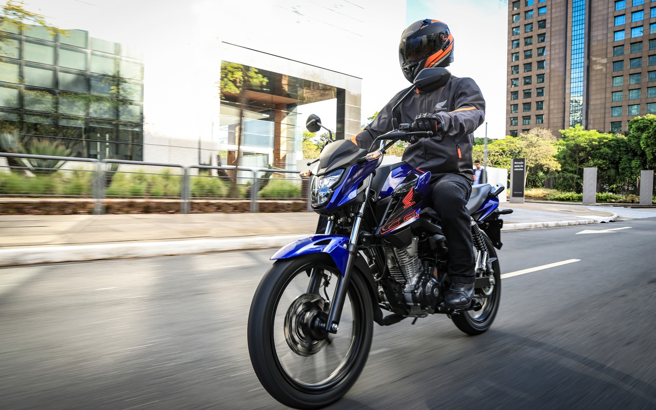 Honda CG 160 Titan 2027 azul em movimento, vista de três quartos dianteiro