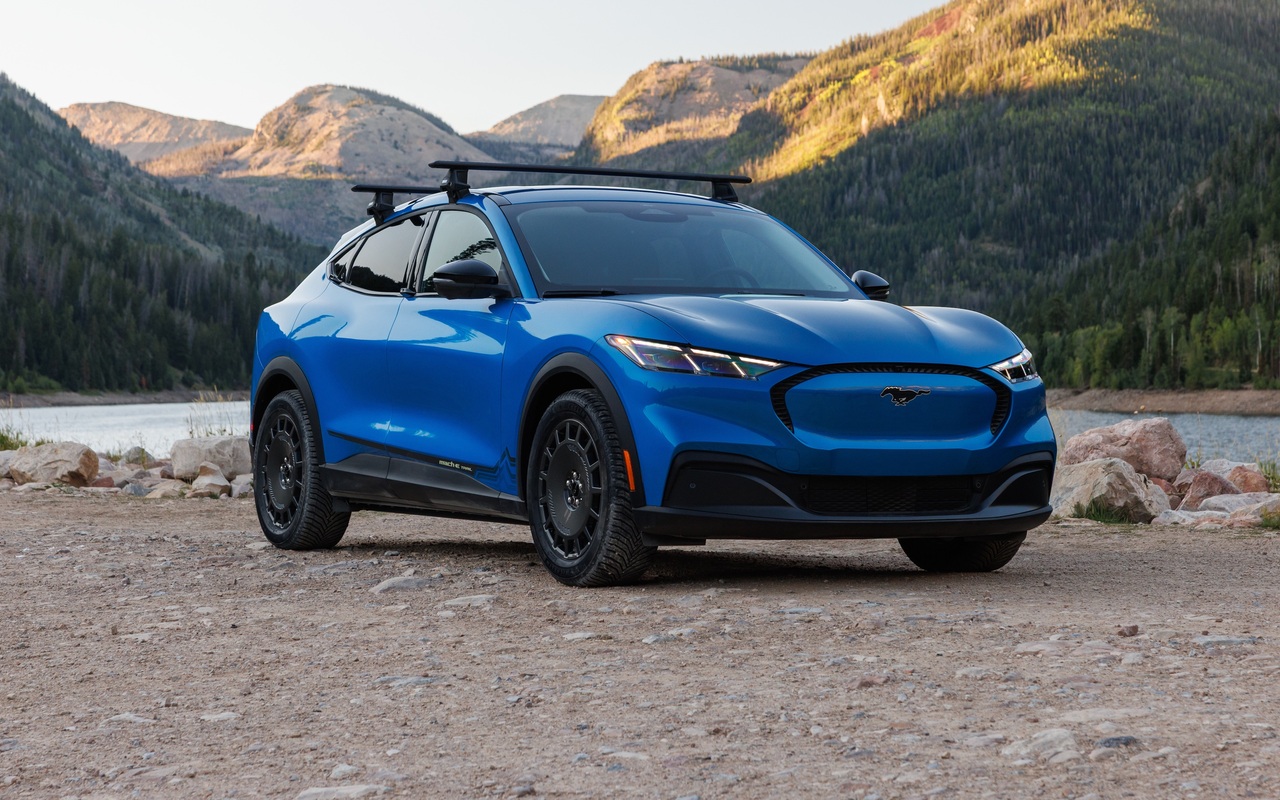 Ford Mustang Mach-E Trail 2027 azul visto de três quartos dianteiro junto a um lago