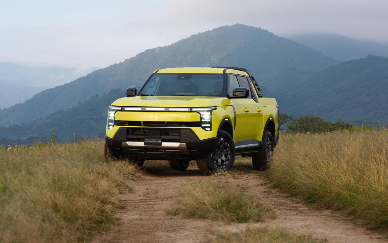 Nissan Frontier Pro PHEV amarela vista de frente em três quartos em uma estrada de terra