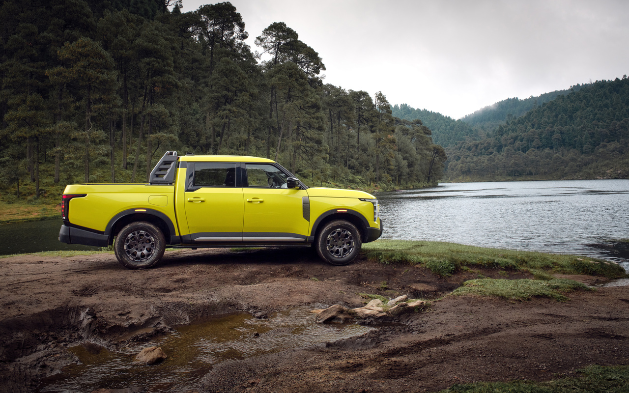 Nissan Frontier Pro PHEV amarela vista de perfil ao lado de um lago