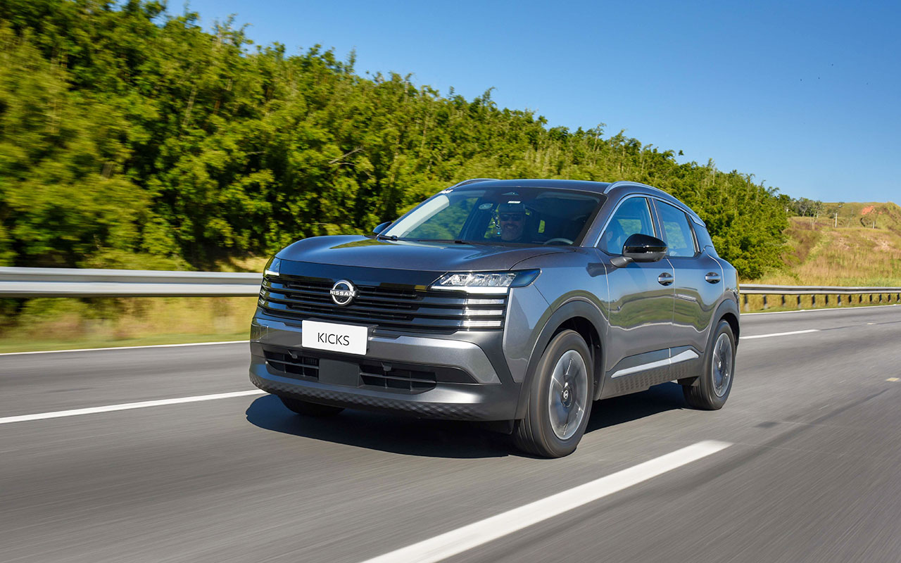 Nissan Kicks Advance cinza visto de frente e de lado em uma estrada