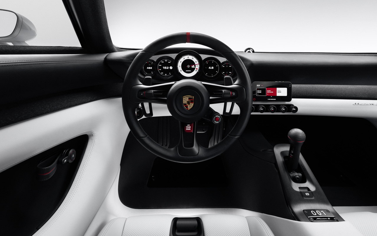 Painel do Porsche Mission S com cinco instrumentos circulares, volante e smartphone no suporte