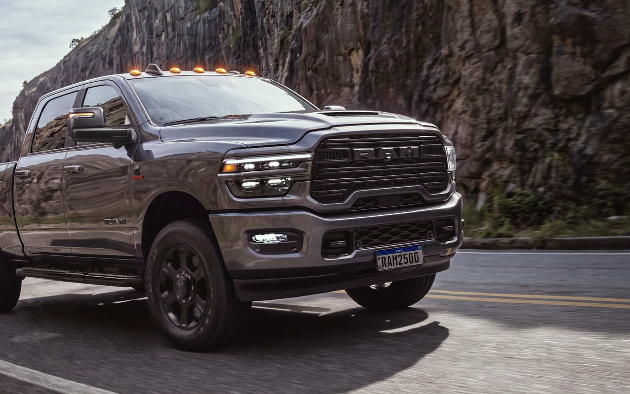 Ram 2500 Laramie Night Edition cinza em vista dianteira na estrada entre paredões de rocha