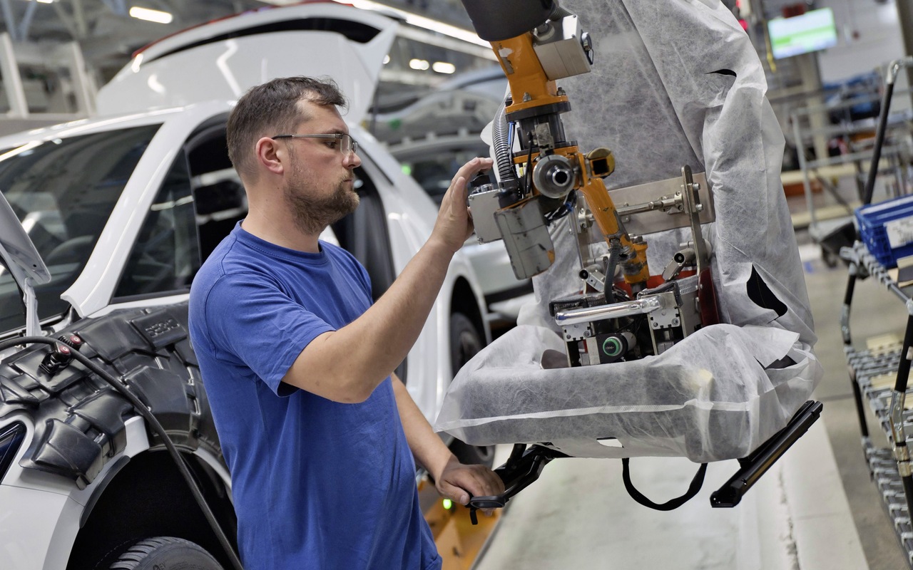Trabalhador opera equipamento de montagem junto a uma carroceria do Volkswagen ID.3 Neo em Zwickau