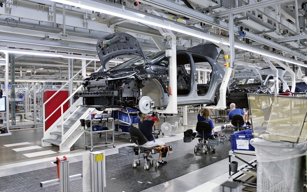 Carroceria de Volkswagen ID.3 Neo suspensa na linha de montagem de Zwickau, com trabalhadores abaixo